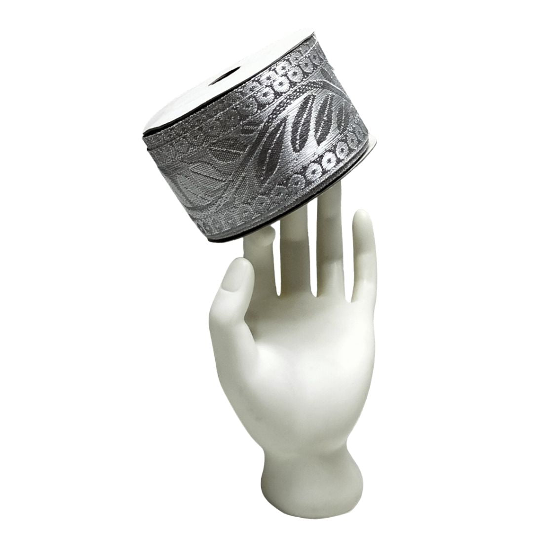 Silver bracelet with leaf design on a white mannequin hand against a white background